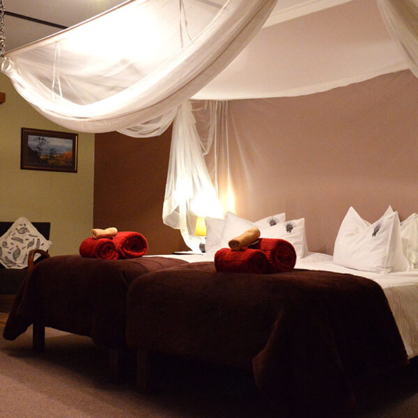 Gemütliches Gästezimmer mit Moskitonetz und liebevoller Einrichtung in der Lodge.