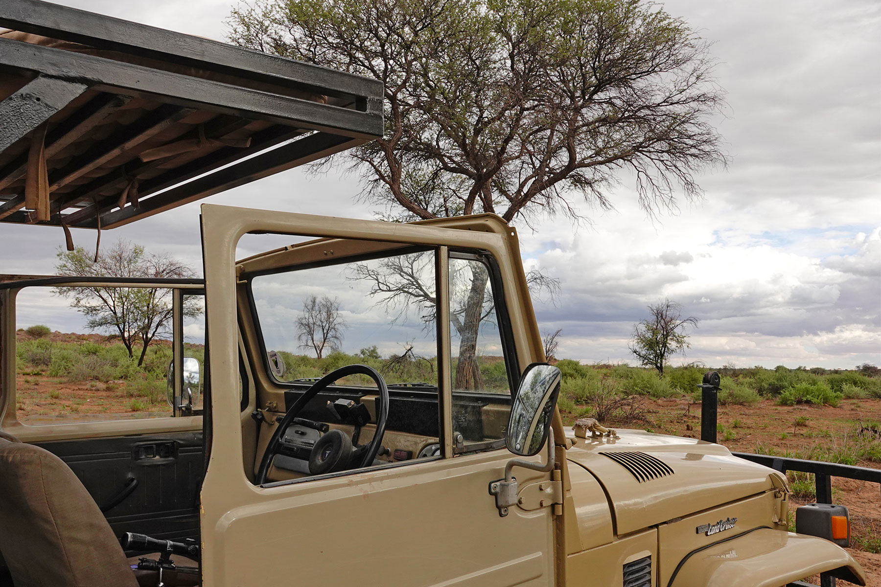 Safari‑Fahrzeug in der Buschlandschaft Namibias bei Ombakata – Gäste auf Wildbeobachtungstour