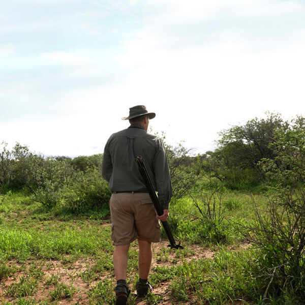 Jäger bei der Pirsch zu Fuß durch Buschland