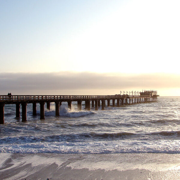 Lange Seebrücke ragt in den Atlantik, Küstenmotiv der Safari-Tour „Best of Namibia“ mit Blick auf Meer und Horizont.