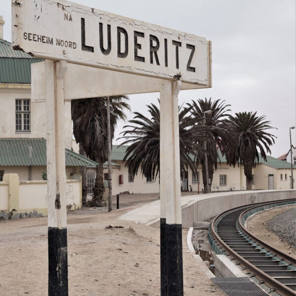 Altes Bahnhofsschild von Lüderitz mit Gleisanlagen, kulturelles Highlight der Safari „Namibia Grand Royale“.