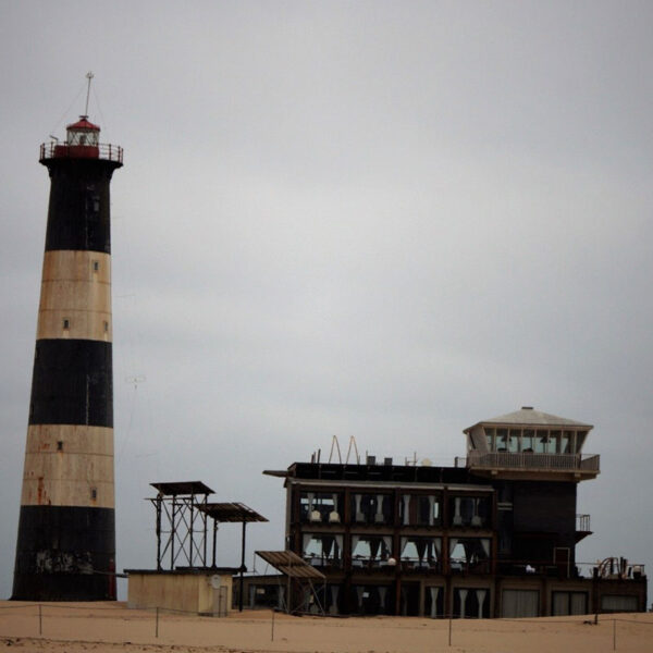 Einsamer Leuchtturm an der rauen Küste Namibias, eindrucksvoller Küstenmoment der Safari „Namibia Grand Royale“.